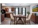 Dining room features a table, six chairs, wood floors, two windows, and brown wooden cabinets at 12039 Quail Dr, Hampton, GA 30228