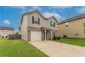 Two story home with neutral siding, black shutters, an attached garage, and a green lawn at 12039 Quail Dr, Hampton, GA 30228