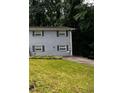 Two-story home with gray brick, dark shutters, and a driveway, nestled on a green hillside at 2436 Glenrock Dr, Decatur, GA 30032