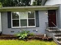 Home exterior showing the front door, window with shutters and landscaped garden bed at 2436 Glenrock Dr, Decatur, GA 30032