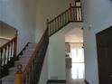 Inviting foyer with a grand staircase, neutral walls, and tiled flooring, leading to the kitchen at 4576 Creek Forestt Trl, Lilburn, GA 30047