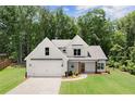 Charming two-story home with a well-manicured lawn, red front door, and traditional architectural details at 65 Harmony Woods Ln, Dallas, GA 30157