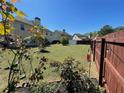 Spacious, well-maintained backyard with lush green grass, defined garden beds, and a wooden fence at 2030 Hydrangea Ln, Austell, GA 30106