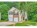 Well-maintained two-story home featuring a two-car garage and lush greenery at 3599 Brookstone Way, Union City, GA 30291