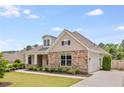 Attractive single-story home featuring stone accents, a side-entry garage, and a well-maintained lawn at 1374 Highland Wood Ct, Auburn, GA 30011