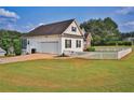 Side view of the home showcasing the garage, white picket fence, and expansive yard at 501 Grace Ct, Temple, GA 30179