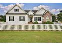 Well-maintained home features a white picket fence, green lawn, and a mix of stone and siding at 501 Grace Ct, Temple, GA 30179