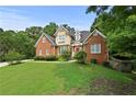 Beautiful two-story brick home with manicured lawn, mature trees, and classic architectural details at 1920 Lee Patrick Dr, Dacula, GA 30019