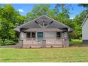 Inviting front porch with craftsman details, white siding, and a vibrant teal door at 2209 Browns Mill Se Rd, Atlanta, GA 30315