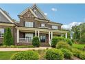 Lovely brick home with a covered front porch, white columns, and manicured shrubs at 107 Equest Dr, Canton, GA 30115