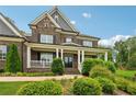 Stately brick home featuring a welcoming front porch and manicured shrubbery at 107 Equest Dr, Canton, GA 30115