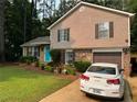 Inviting split-level home with tidy lawn, charming shutters, and a paved driveway leading to an attached garage at 4678 Browns Mill Ferry Rd, Lithonia, GA 30038
