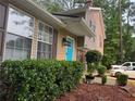 Two-story home with tan siding, a bright blue front door, and well-manicured landscaping in the front at 4678 Browns Mill Ferry Rd, Lithonia, GA 30038