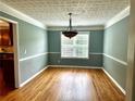 Dining room has warm hardwood flooring, a decorative ceiling, and plenty of natural light through a bright window at 10175 Hemlock Way, Jonesboro, GA 30238