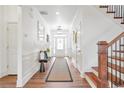 Bright foyer with hardwood floors, white wainscoting, and an elegant staircase at 5310 Chestnut Dr, Cumming, GA 30040