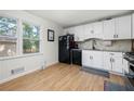 Bright kitchen with white cabinets, stainless steel appliances, and wood-look flooring at 245 Amanda Ct, Stockbridge, GA 30281