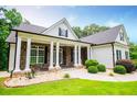 This beautiful home offers a stone facade, a covered porch with stately columns, and a sprawling green lawn at 7037 Tara Dr, Villa Rica, GA 30180