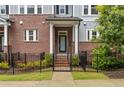 Close up of a brick townhome featuring a black wrought iron fence and covered entryway with white columns at 2734 Bell Se Dr, Smyrna, GA 30080