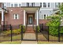 Close up of a brick townhome featuring a black wrought iron fence and covered entryway with white columns at 2734 Bell Se Dr, Smyrna, GA 30080
