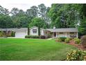 Traditional-style home with a well-manicured lawn, mature trees, and a welcoming porch swing, ideal for suburban living at 3850 Beya Way, Atlanta, GA 30340