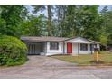 Exterior view showcasing the house with a carport and a well-manicured lawn at 4922 Glenside Ct, Stone Mountain, GA 30088