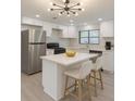 A bright kitchen boasts stainless steel appliances, white cabinetry, and an island with seating at 4922 Glenside Ct, Stone Mountain, GA 30088
