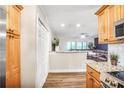 Bright, open kitchen featuring wooden cabinetry, stainless appliances, and a view into the living area at 4266 Roswell Ne Rd # L3, Atlanta, GA 30342