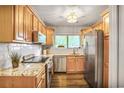 Well-lit kitchen with stainless steel appliances, wooden cabinets, granite countertops, and subway tile backsplash at 4266 Roswell Ne Rd # L3, Atlanta, GA 30342