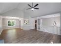 An open concept living room features wood flooring, vaulted ceilings, and elegant lighting fixtures at 232 Barrett Springs Way, Canton, GA 30115