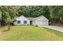 Inviting single-story home featuring a well-manicured lawn and an attached two-car garage at 506 Bluff Ct, Woodstock, GA 30188