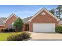 Well-maintained brick home featuring a two-car garage and mature landscaping at 115 Pinnacle Ln, Mcdonough, GA 30253