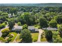An aerial view showcases this beautiful home with lush surroundings, a long driveway, and mature trees at 385 Stonebridge Trl, Roswell, GA 30075