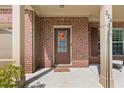 Close-up of the brick front porch with a cozy seating area and inviting front door with seasonal wreath at 224 Farm Manor Ct, Lawrenceville, GA 30045