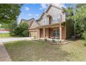 Inviting two-story home with a well-kept lawn, brick accents, and a cozy covered front porch at 224 Farm Manor Ct, Lawrenceville, GA 30045
