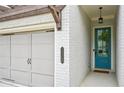 Charming home entrance with a teal-colored door, carriage lighting, and brick wall at 20056 Windalier Way, Roswell, GA 30076