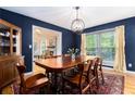 Elegant dining room featuring dark blue walls, hardwood floors, and large window for natural light at 2960 Cedar Knoll Dr, Roswell, GA 30076