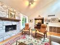 Cozy living room showcases a stone fireplace, hardwood floors, and comfortable seating for relaxation at 2960 Cedar Knoll Dr, Roswell, GA 30076