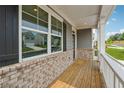 Inviting front porch with brick accents, white railing, wood decking, and views of the neighborhood at 96 Quail Bend Way, Dallas, GA 30157