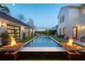 Beautiful backyard pool area complete with a cozy fire pit, outdoor lighting, and lush landscaping at 7165 Cordery Rd, Cumming, GA 30040