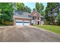 Two-story brick home with a two-car garage, long driveway and well-maintained lawn and landscaping at 863 Fairlong Nw Way, Acworth, GA 30101
