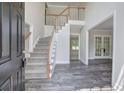 Bright foyer with hardwood floors, stairs with white railing, and a view into other rooms at 863 Fairlong Nw Way, Acworth, GA 30101