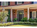 Elegant home entrance with a black front door, brick facade, and manicured landscaping at 4729 Woodland Brook Se Ct, Atlanta, GA 30339