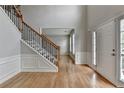 Bright foyer with hardwood floors, staircase, and paneled walls at 148 Crystal Downs Way, Suwanee, GA 30024