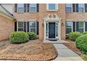 Close-up of the front entrance with a brick facade and manicured shrubs at 148 Crystal Downs Way, Suwanee, GA 30024