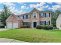 Charming two-story brick home with lush green lawn and dark shutters at 148 Crystal Downs Way, Suwanee, GA 30024
