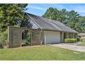 A brick fence leads to the front of this single-story home with an attached two-car garage at 3080 Keenan Rd, Atlanta, GA 30349