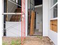 Entryway of unfinished modern home, showing a wooden staircase and unique dark accent wall at 5210 Brownlee Rd, Stone Mountain, GA 30087