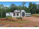 Contemporary home featuring a unique design with black and white accents nestled amongst lush greenery at 5210 Brownlee Rd, Stone Mountain, GA 30087