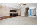 Spacious open-concept living area with hardwood flooring, leading to a staircase and a modern kitchen at 72 Fern Walk, Lawrenceville, GA 30045