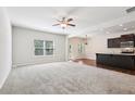 Bright living area showcasing neutral carpeting, large windows, and views into the modern eat-in kitchen at 72 Fern Walk, Lawrenceville, GA 30045